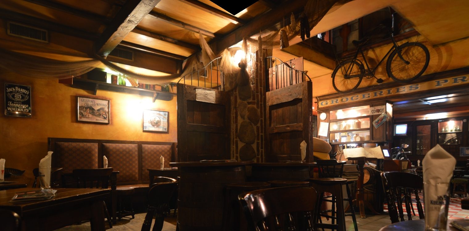 La sala interna del Molly's Pub: travi in legno, botti, vetrinette e una bicicletta d'epoca appesa al soffitto.